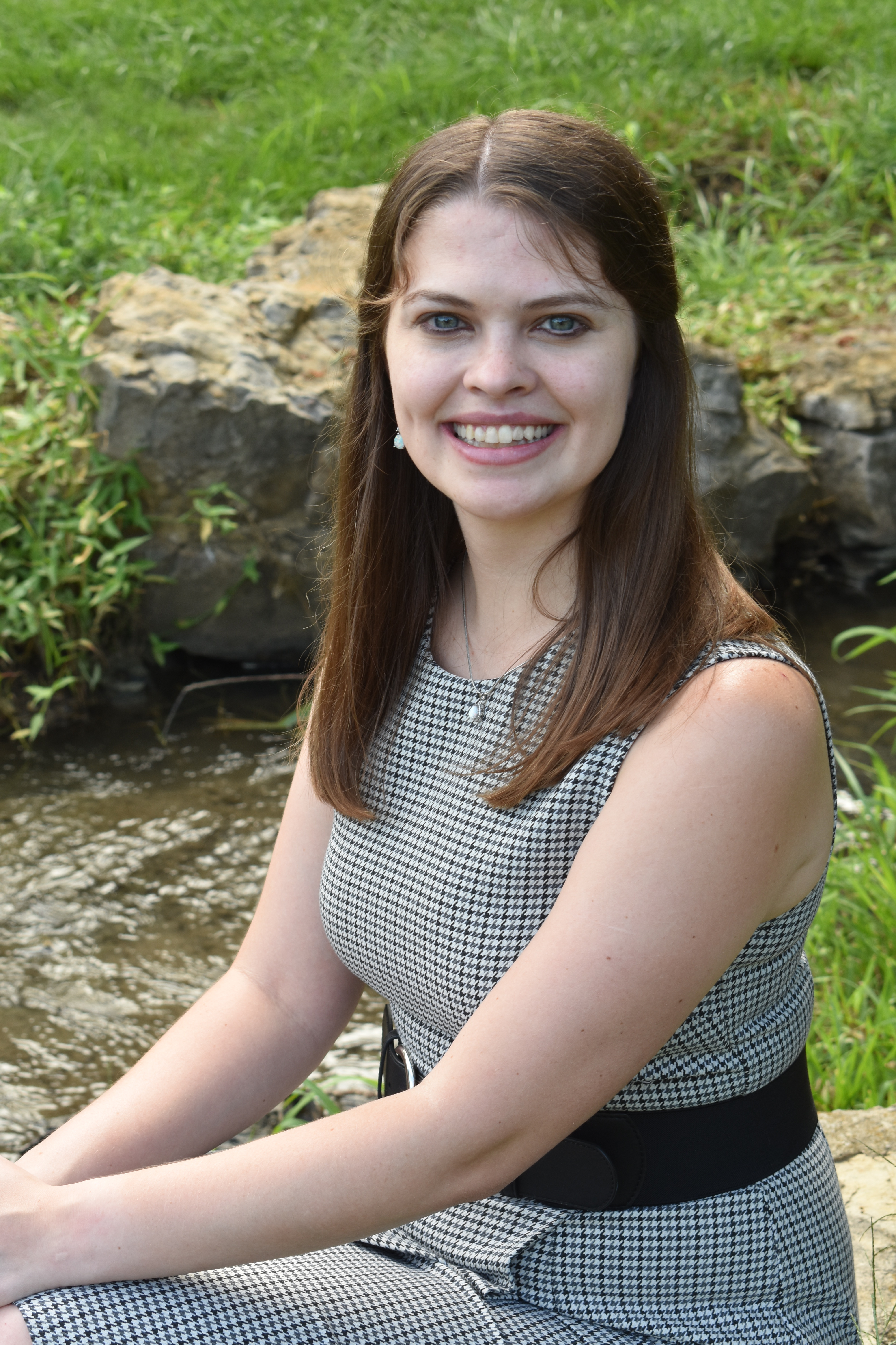 Photograph of Sarah Lamm sitting beside brook 