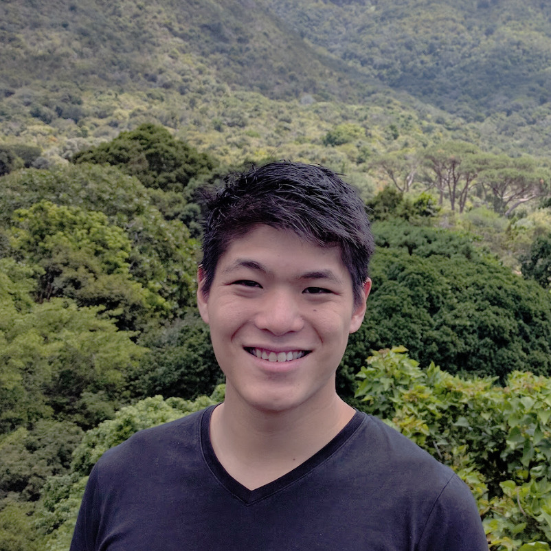 headshot of John Wu with forest in background